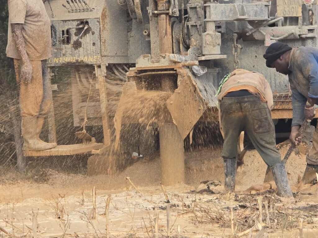 Borehole drilling in progress with mud and cuttings flowing