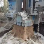 Water and drill cuttings flowing from a borehole during drilling in Kenya